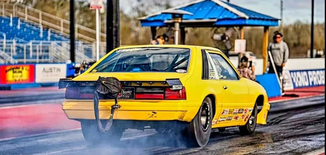 Yellow Sixty-Foot Performance race car launching at the drag strip